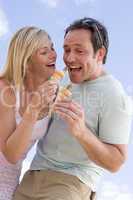 Couple outdoors eating ice cream and smiling