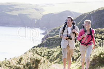 Couple on cliffside outdoors walking and smiling