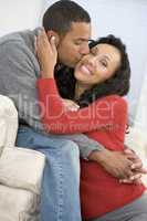 Couple in living room kissing and smiling