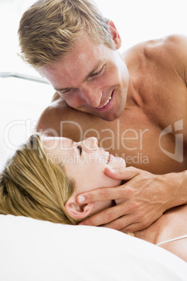 Couple lying in bed smiling