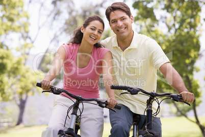 Couple on bikes outdoors smiling