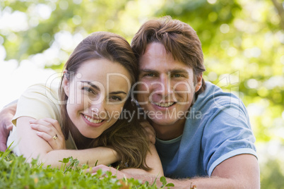 Couple lying outdoors smiling