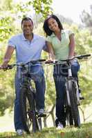 Couple on bikes outdoors smiling