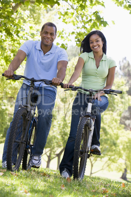 Couple on bikes outdoors smiling