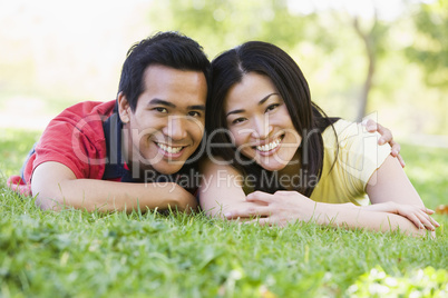 Couple lying outdoors smiling