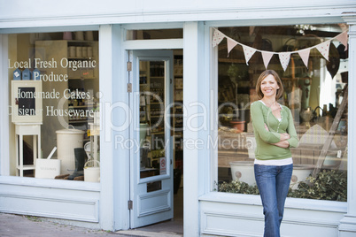 Woman standing in front of organic food store smiling