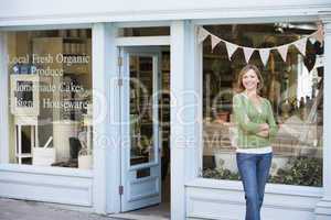 Woman standing in front of organic food store smiling