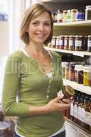 Woman in market looking at preserves smiling