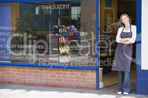 Woman standing in doorway of restaurant smiling