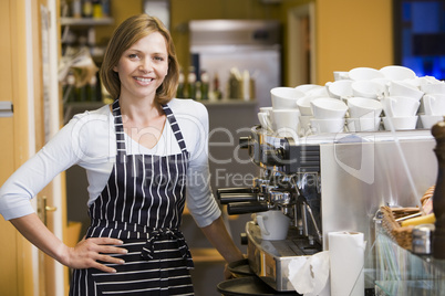 Woman making coffee in restaurant smiling