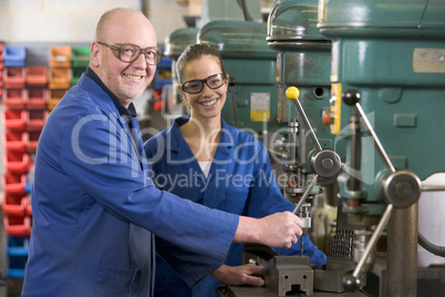 Two machinists working on machine