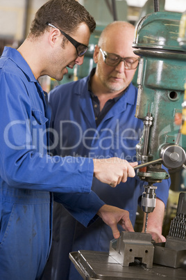 Two machinists working on machine