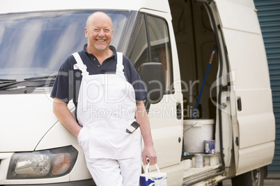 Painter standing with van smiling