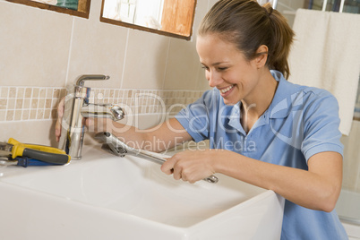 Plumber working on sink smiling