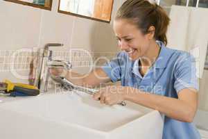 Plumber working on sink smiling