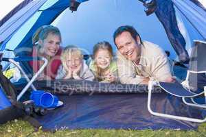 Family camping in tent smiling
