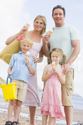 Family standing at beach with ice cream smiling