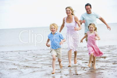 Family running on beach smiling