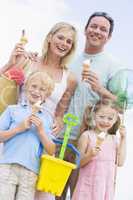 Family at beach with ice cream cones smiling