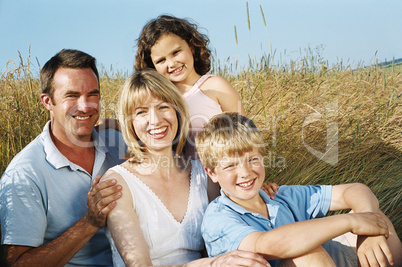 Family sitting outdoors smiling