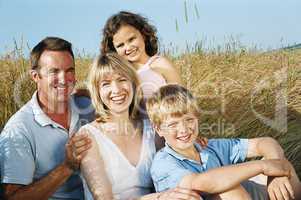 Family sitting outdoors smiling