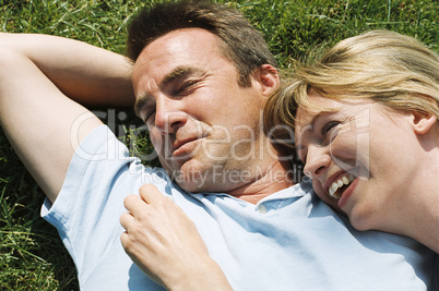 Couple lying outdoors smiling