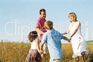 Family playing outdoors smiling