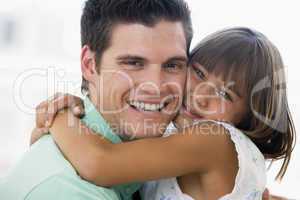 Man and young girl hugging and smiling