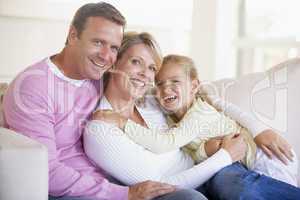 Family sitting in living room smiling