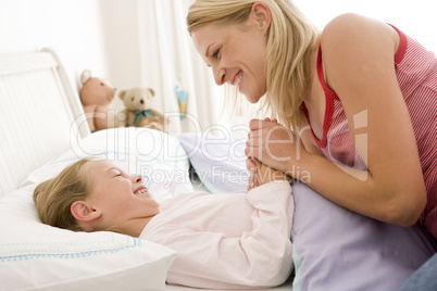 Woman with young girl in bed smiling