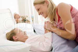 Woman with young girl in bed smiling