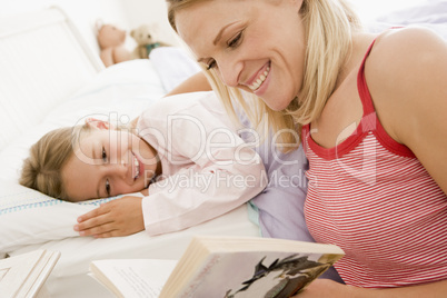 Woman with young girl in bed smiling