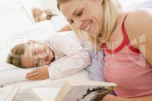 Woman with young girl in bed smiling