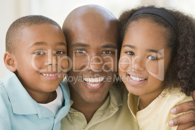 Man and two young children embracing and smiling