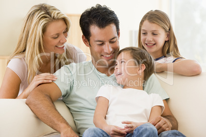 Family sitting in living room smiling