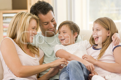 Family sitting in living room smiling