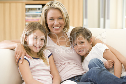 Woman and two young children in living room smiling