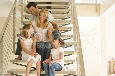 Family sitting on staircase smiling