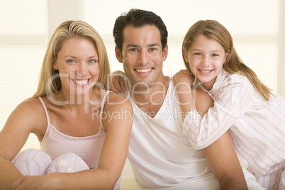 Family sitting in bed smiling