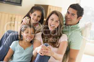 Family sitting in living room smiling