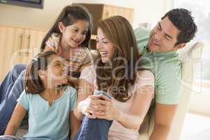 Family sitting in living room smiling