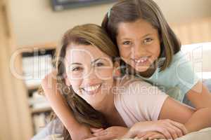 Woman and young girl in living room smiling