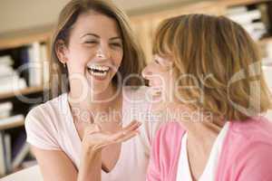 Two women sitting in living room talking and laughing