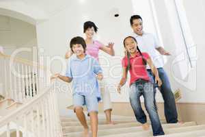 Family running down staircase smiling