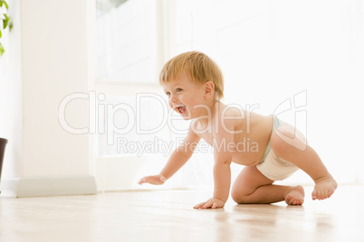 Baby crawling indoors smiling