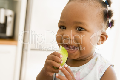 Young girl eating apple indoors