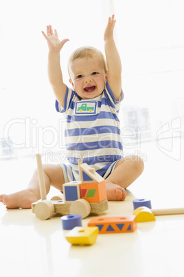 Baby indoors playing with truck