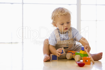 Baby indoors playing with toy truck