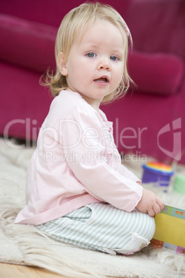 Baby in living room with toys and book