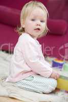 Baby in living room with toys and book